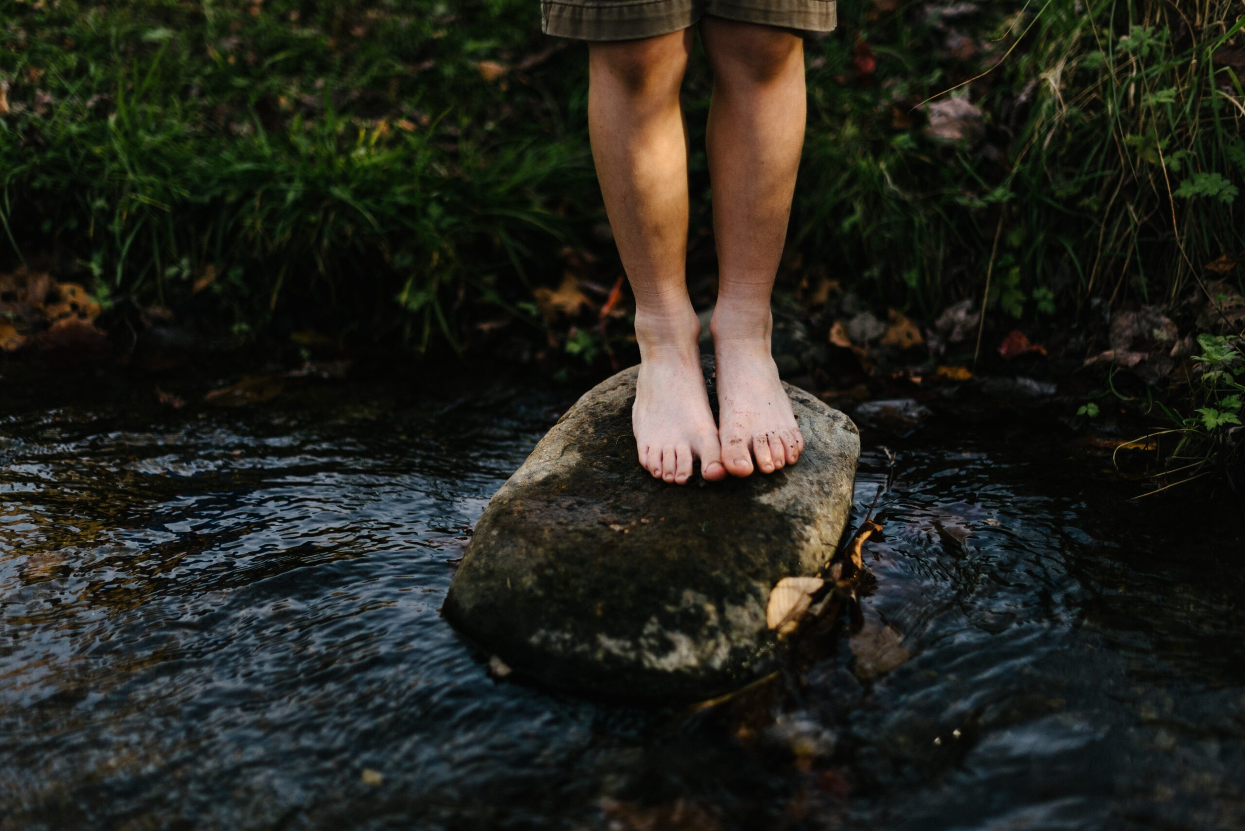 Piedi su un sasso nel fiume